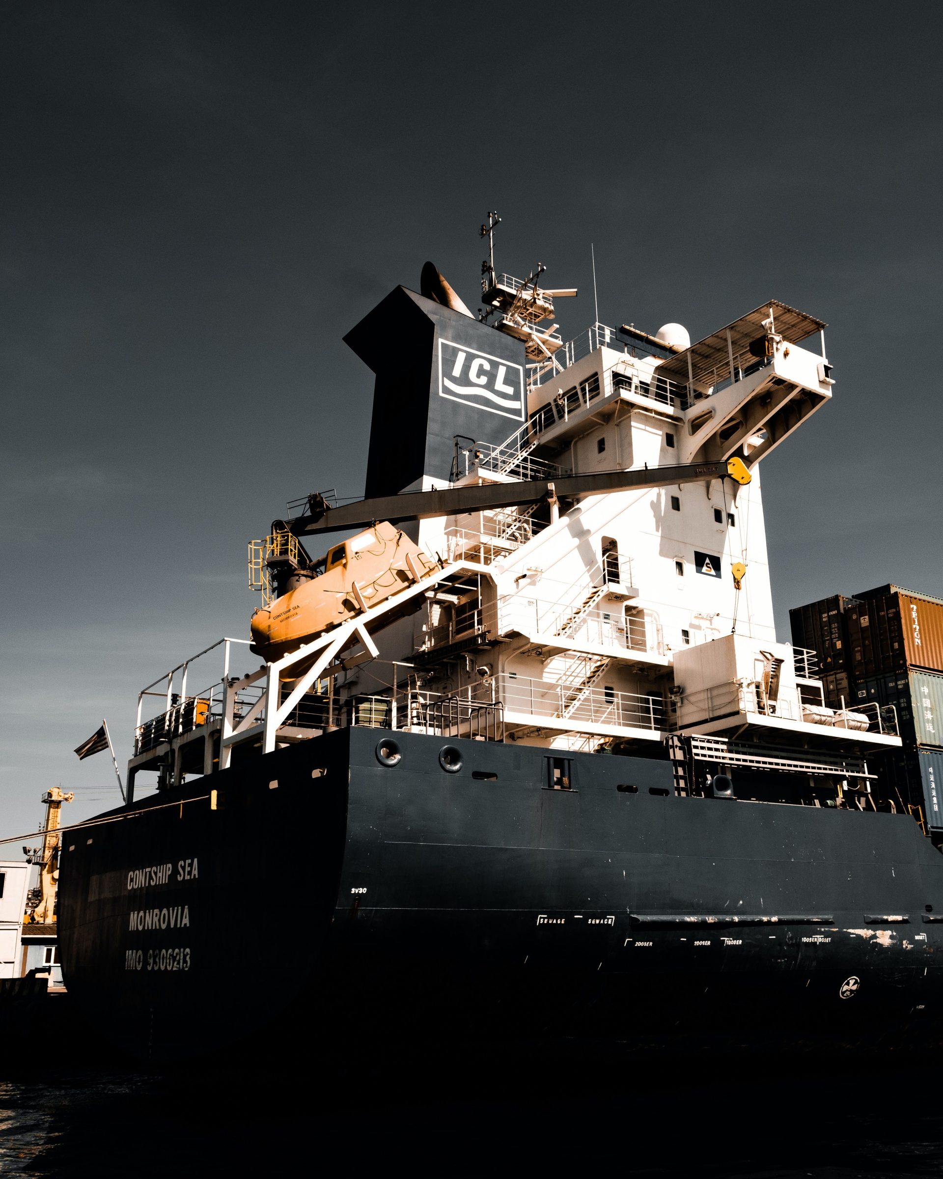 Large cargo vessel docked at Istanbul harbor under dramatic skies, showcasing global trade.